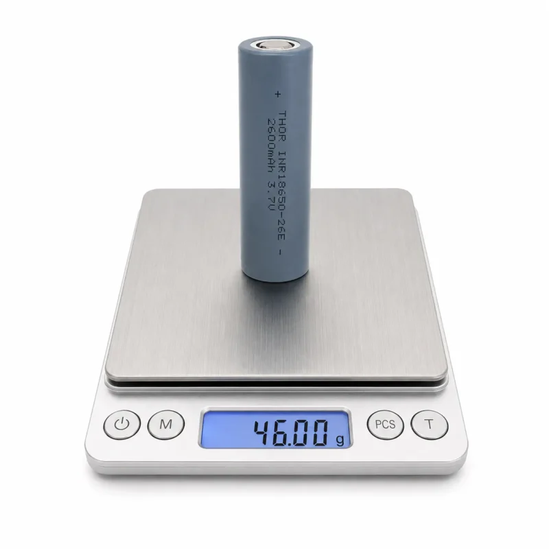 THOR 3.7V 2600mAh 18650 NMC lithium-ion battery cell on a digital scale showing 46.00 g